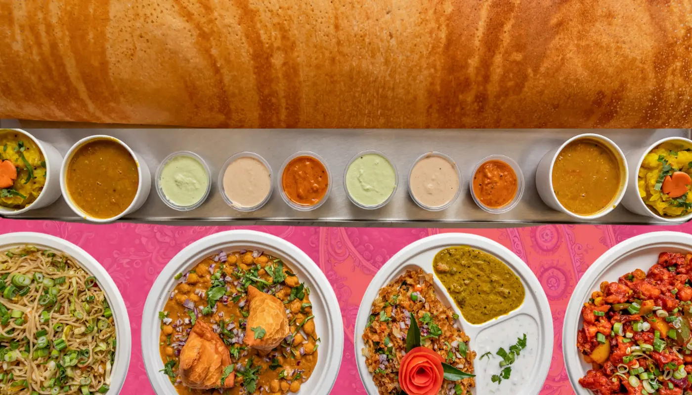 SVG Family Dosa with a row of chutneys, curries, noodles and chilli dishes